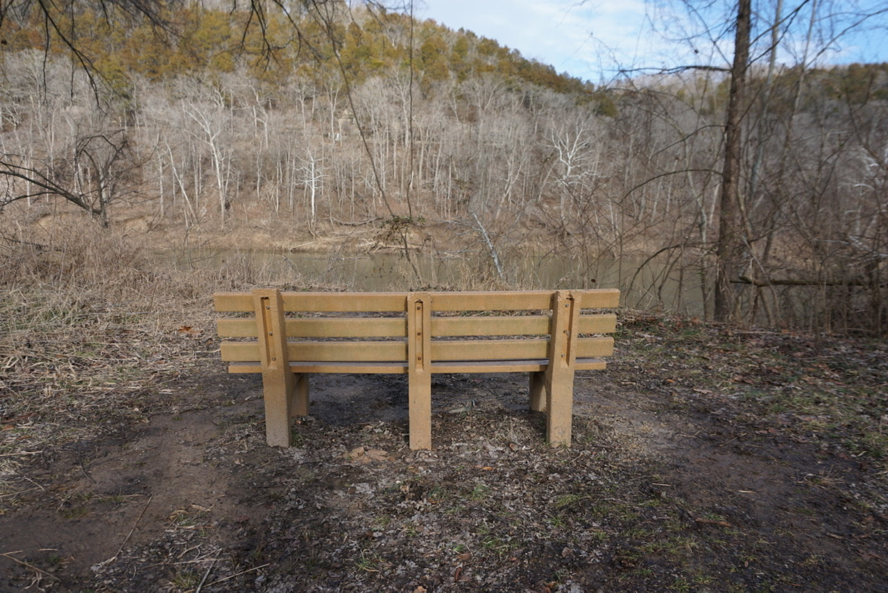 Empty bench facing the wooded hillside across the Meramec River at Route 66 State Park